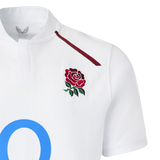 The England 26/27 Classic Home Jersey by Castore features a white design with a maroon rose emblem, thin maroon shoulder stripe, and a large blue "O"—a must-have for rugby fans.