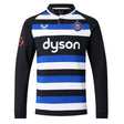 The Bath 26/27 Classic Long Sleeve Home Jersey by Castore features black, blue, and white horizontal stripes, a “dyson” sponsor logo, star and crest on the chest, and black sleeves—a timeless heritage rugby shirt from Castore.