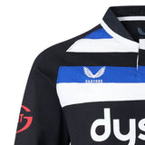 Close-up of the upper left portion of the Bath 26/27 Classic Long Sleeve Home Jersey by Castore, featuring black, white, and blue stripes along with the Castore logo and partial Dyson sponsor text, showcasing its classic design inspired by heritage rugby shirts.