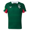 The Leicester 26/27 Replica Home Jersey by Castore features a green short-sleeved design with a white collar, red underarm panels, and distinctive logos such as Castore, Breedon, and a tiger emblem on the chest. This replica jersey by Castore authentically mirrors the official Leicester Tigers home kit for the 2026/27 season.
