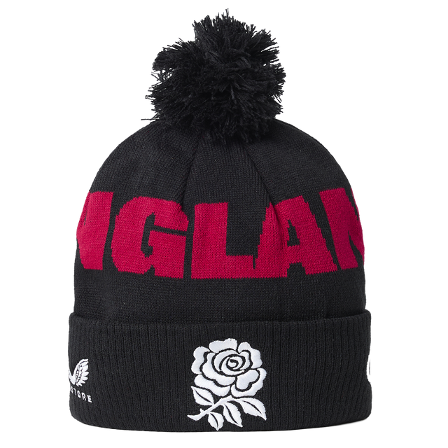 The England 26/27 Bobble Beanie by Castore is a black knit beanie featuring a pom-pom, bold red “ENGLAND” lettering, and a white rose emblem on the fold—an essential winter accessory for England supporters and the perfect Castore beanie for chilly rugby match days.