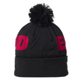 The England 26/27 Bobble Beanie by Castore is a black knit hat with a large pom-pom on top, featuring bold red partial lettering wrapping around the design—making it the perfect winter accessory for England rugby supporters.