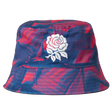 The Castore England 26/27 Reversible Bucket Cap features blue and red patterns and a white embroidered rose on the front, taking inspiration from the iconic England rugby cap.