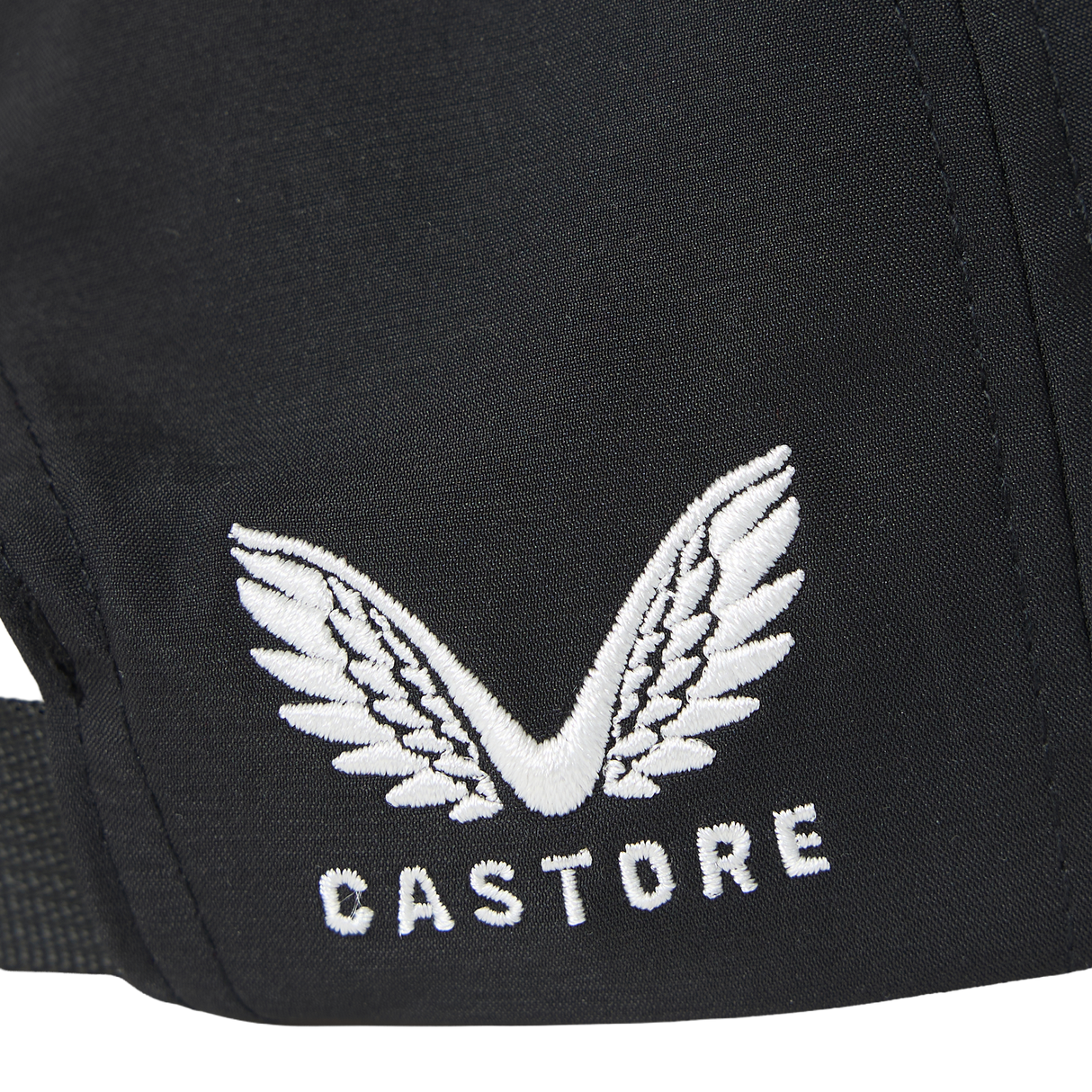 Close-up of a black fabric featuring an embroidered white winged logo and the word “CASTORE” beneath it, as seen on the Castore England 26/27 Team Cap.
