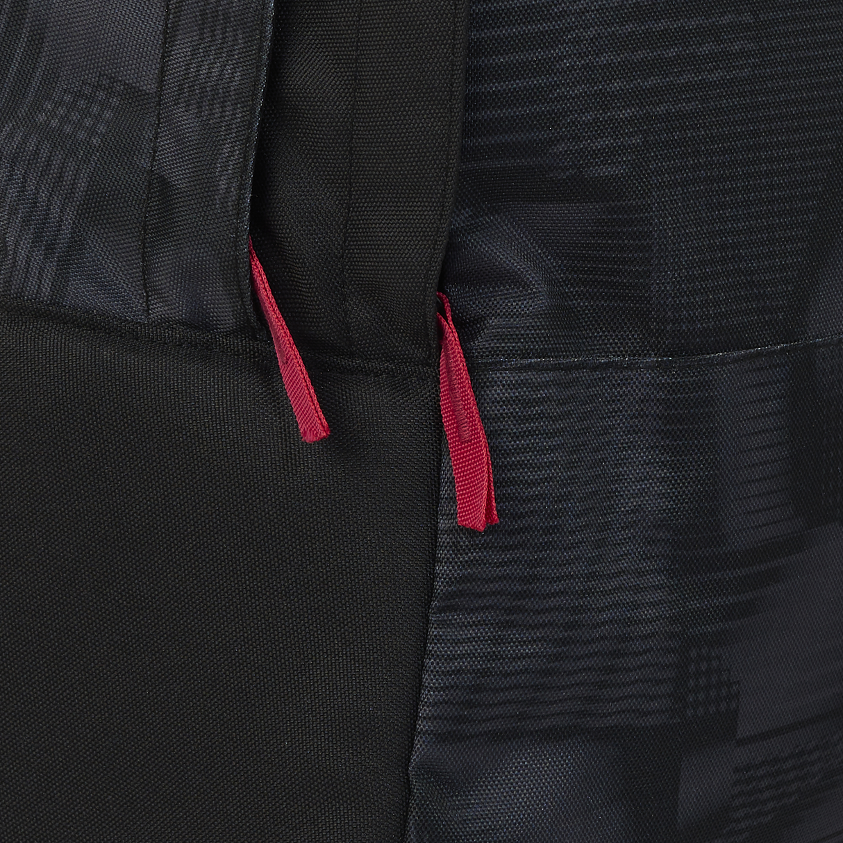 Close-up of the England 26/27 Backpack by Castore, featuring a sleek black design with two red zipper pulls that showcase its stylish and durable construction.