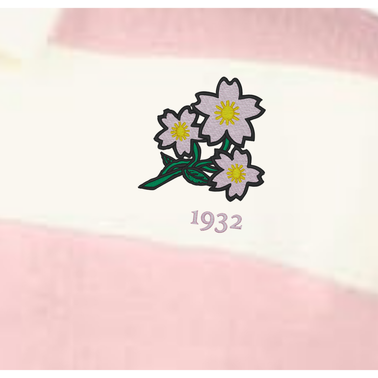 The EMB Augusta Women's Vintage Japan Prep Street Rugby Crop features three pale pink flowers with yellow centers and green stems above "1932," set on pink and white striped fabric for a retro rugby style.