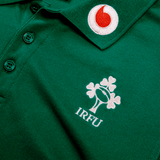 The Ireland 24 Team Polo by Canterbury features a green design with a ribbed collar and cuffs, adorned with the IRFU logo featuring a shamrock and rugby ball, plus embroidered sponsor logos.