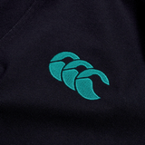 The Ireland 24 Team Polo by Canterbury features a close-up of expertly embroidered teal logo with three overlapping shapes on a dark background, complete with a ribbed collar and cuffs.