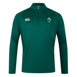 The Ireland 24 VapoDri First Layer by Canterbury is a green long-sleeve sports jacket with a quarter-zip, featuring VapoDri technology. It showcases a white logo on the left chest and a small white emblem on the right side, making it ideal for intense training sessions.