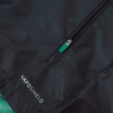 Close-up of a black Ireland 24 Wind Resistant Jacket by Canterbury featuring a zippered pocket with a green pull tab. The "VAPOSHIELD" text is visible near the bottom, highlighting its advanced Vaposhield technology.