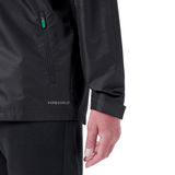 Close-up of a person wearing the Ireland 24 Wind Resistant Jacket by Canterbury, marked with "Vaposhield" near the hem. The jacket features a zippered pocket on the side, along with part of the person's arm and hand visible in the shot.