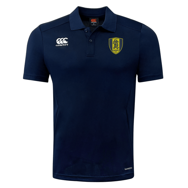 A navy blue Gotham Knights Club Dry Polo shirt by EMB Canterbury, featuring short sleeves, a yellow and black shield emblem on the left chest, and white logos on the right chest and sleeve. The shirt integrates Vapodri Technology to ensure breathability for ultimate comfort.