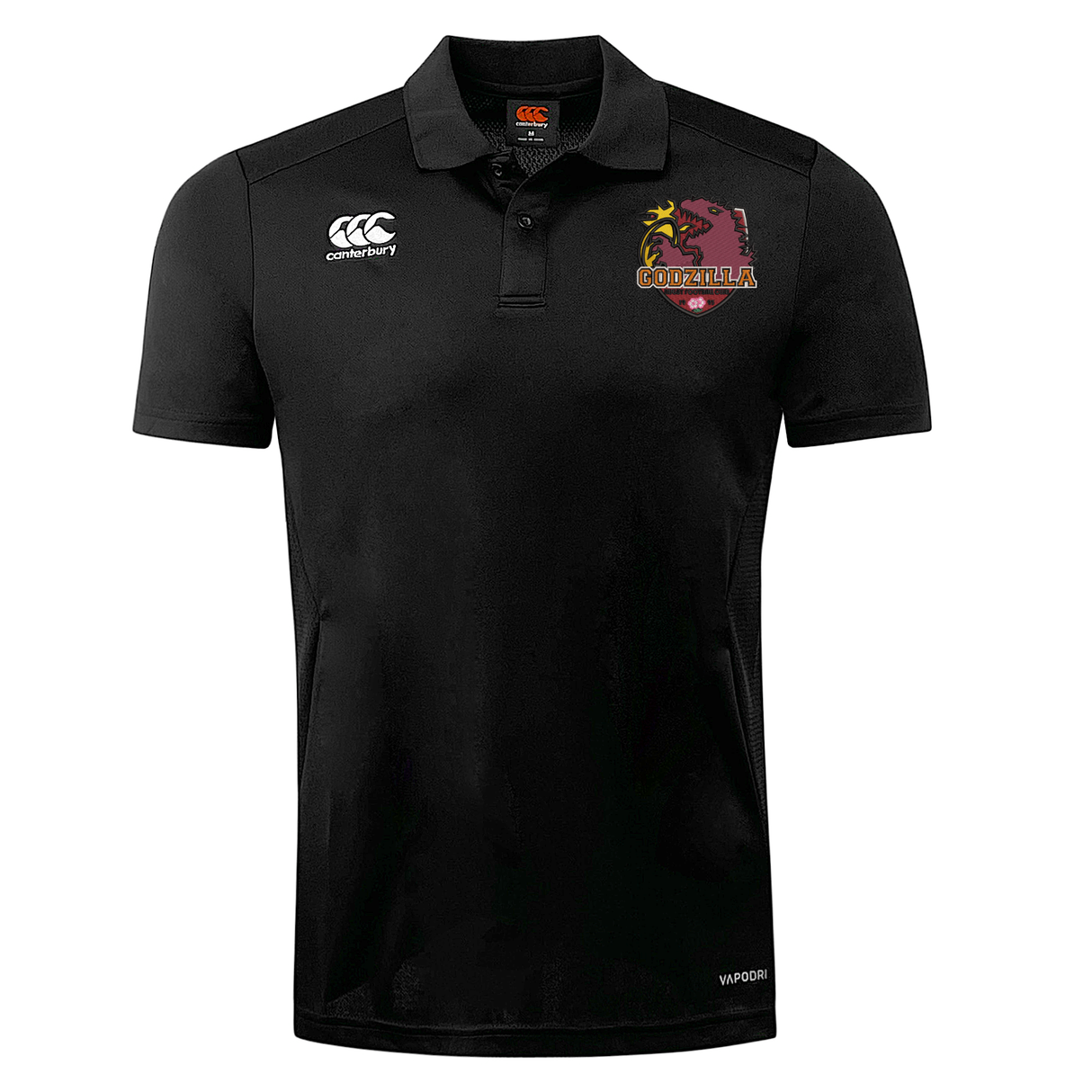 The Godzilla Rugby Football Club Club Dry Polo by EMB Canterbury is a black polo shirt featuring Vapodri technology for breathable comfort, with a white EMB Canterbury logo on the right chest and a maroon, yellow, and white Godzilla-themed emblem on the left chest.