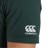 A person wearing the Canterbury California CCC Flag Club T-shirt by WRS Canterbury, crafted from a soft cotton blend in dark green, features white embroidered Canterbury branding on the sleeve—perfect for displaying your rugby pride.
