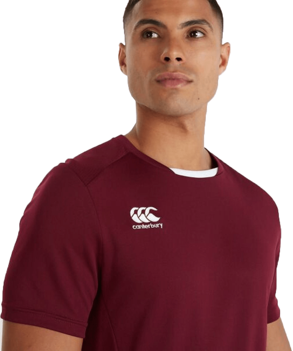 A man wearing a Canterbury Club Dry Tee, maroon t-shirt.