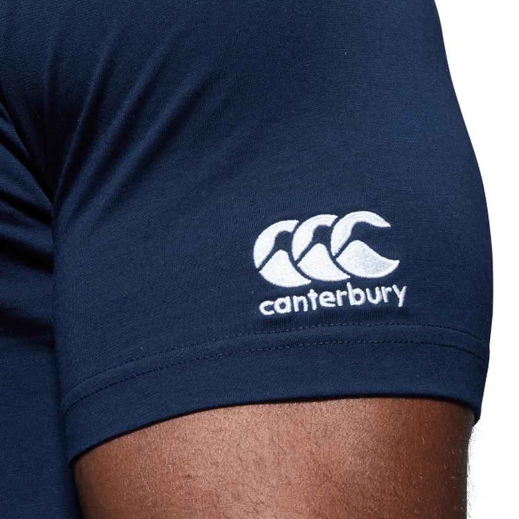 Close-up of a person's upper arm wearing a navy blue WRS Canterbury Texas CCC Flag Club T-shirt, featuring the white Canterbury logo and text embroidered on the sleeve.