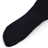 Close-up of a foot wearing the Ireland 25/26 Alternate Socks by Canterbury, featuring ankle and arch support, set against a white background.