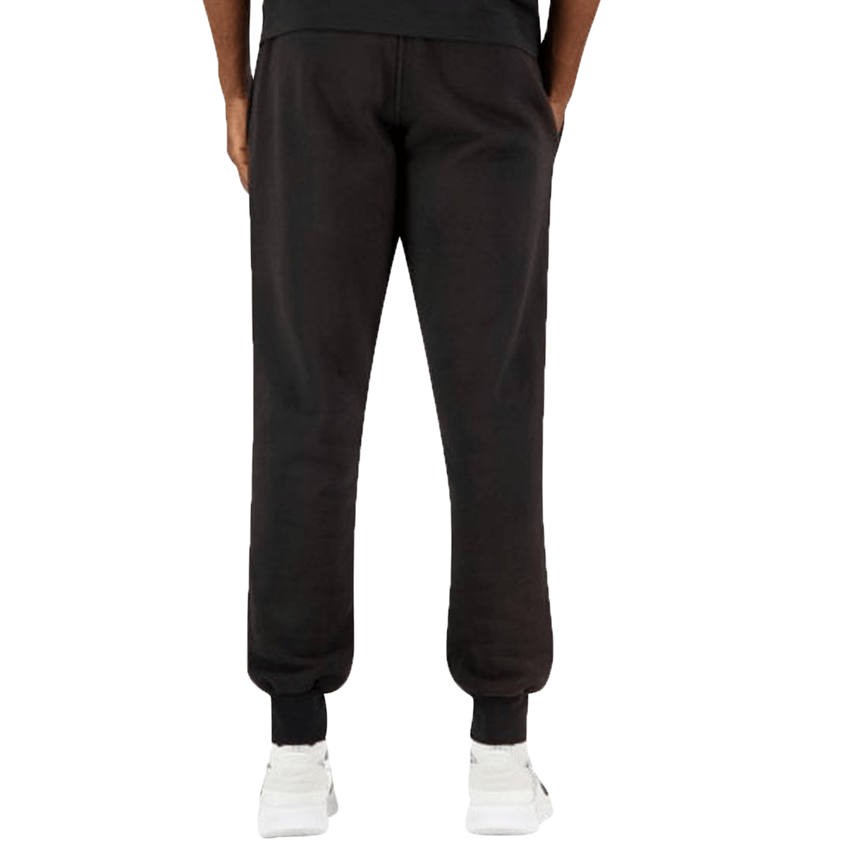 A person from the waist down wearing black Canterbury Anchor fleece pants with an elasticated waistband and white sneakers, standing against a plain background.