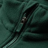 Close-up of the Canterbury Ireland 26 Retro Fleece 1/4 Zip, featuring its distinctive green fabric with a partially closed plastic zipper that highlights the texture and detailing of both the fleece and the zipper.