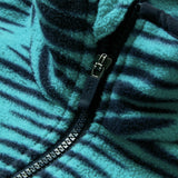 Close-up of the Ireland 26 Retro Fleece 1/4 Zip by Canterbury, featuring turquoise and navy stripes, a partially unzipped black zipper, and soft textured fleece fabric.