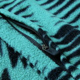 Close-up of the Ireland 26 Retro Fleece 1/4 Zip by Canterbury, featuring a turquoise and black patterned rugby fleece fabric with a partially unzipped black quarter-zip, echoing the classic style of Canterbury.
