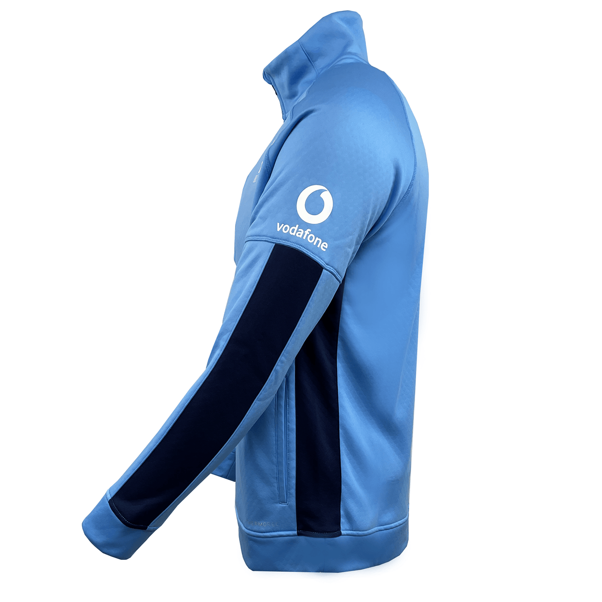 The Ireland Rugby 1/2 Zip Training Top by Canterbury comes in light blue and features a dark blue stripe on the sleeve along with the Vodafone logo on the upper arm. It incorporates ThermoReg technology, making it perfect for training sessions.