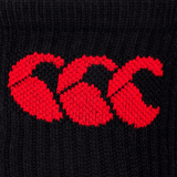 Close-up of a red embroidered Canterbury logo on a black cotton rich fabric.