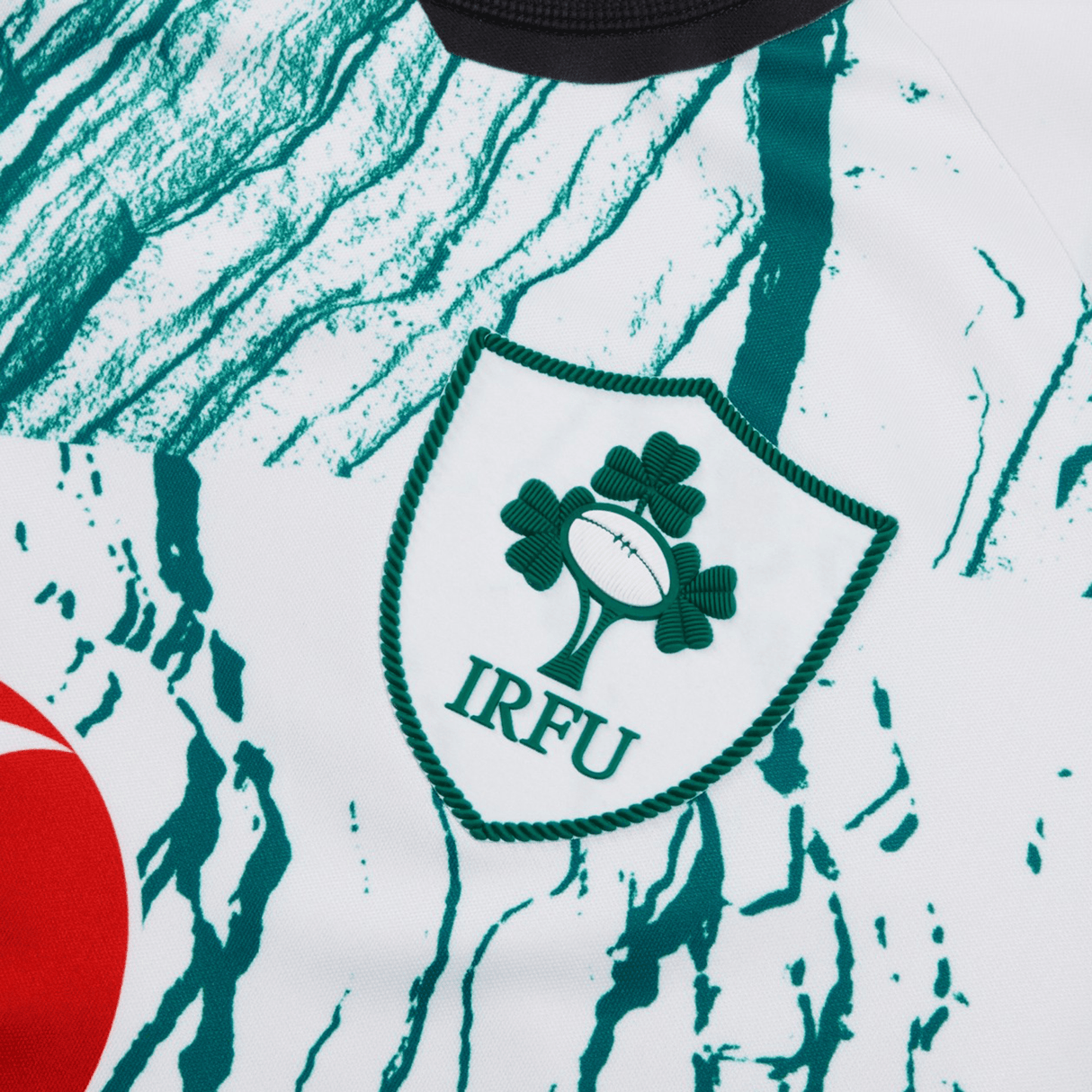Close-up view of the Canterbury Ireland 24 Alternate Test Jersey with the IRFU logo prominently displayed. The VapoDri super slim fit jersey features green and white patterns on a white background.