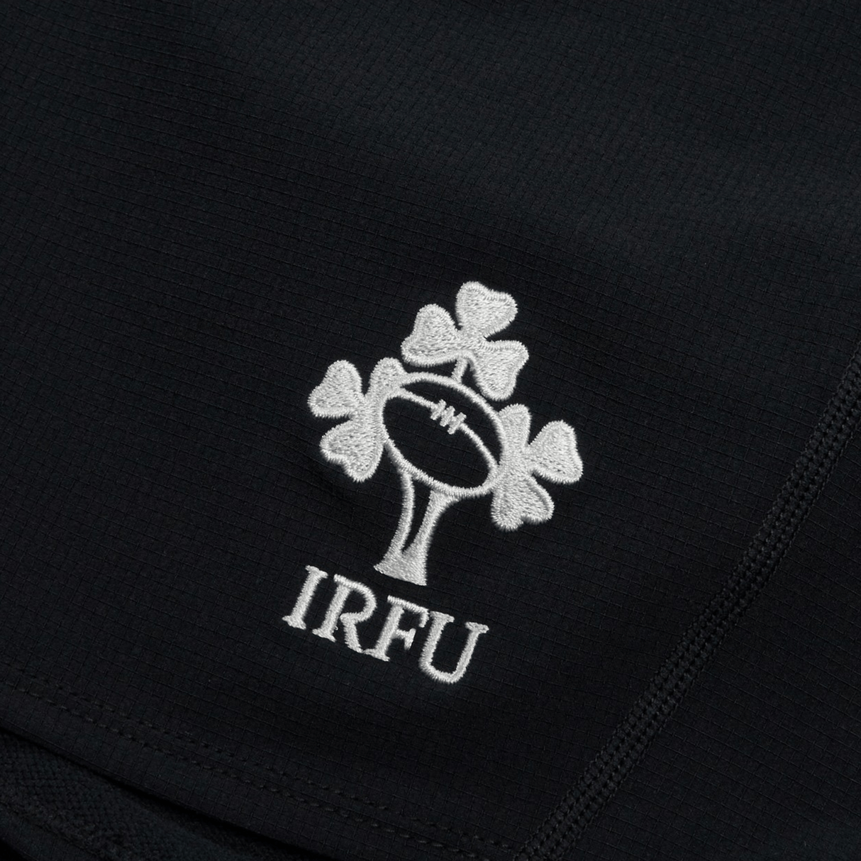 Close-up of the Ireland 24 Training Short by Canterbury, showcasing black fabric with a white IRFU logo that features a rugby ball and shamrock design.