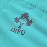 Close-up of the teal fabric from the Ireland 26 Tech Drill Top by Canterbury, showcasing the IRFU logo—with its rugby ball and shamrocks—printed in dark ink.