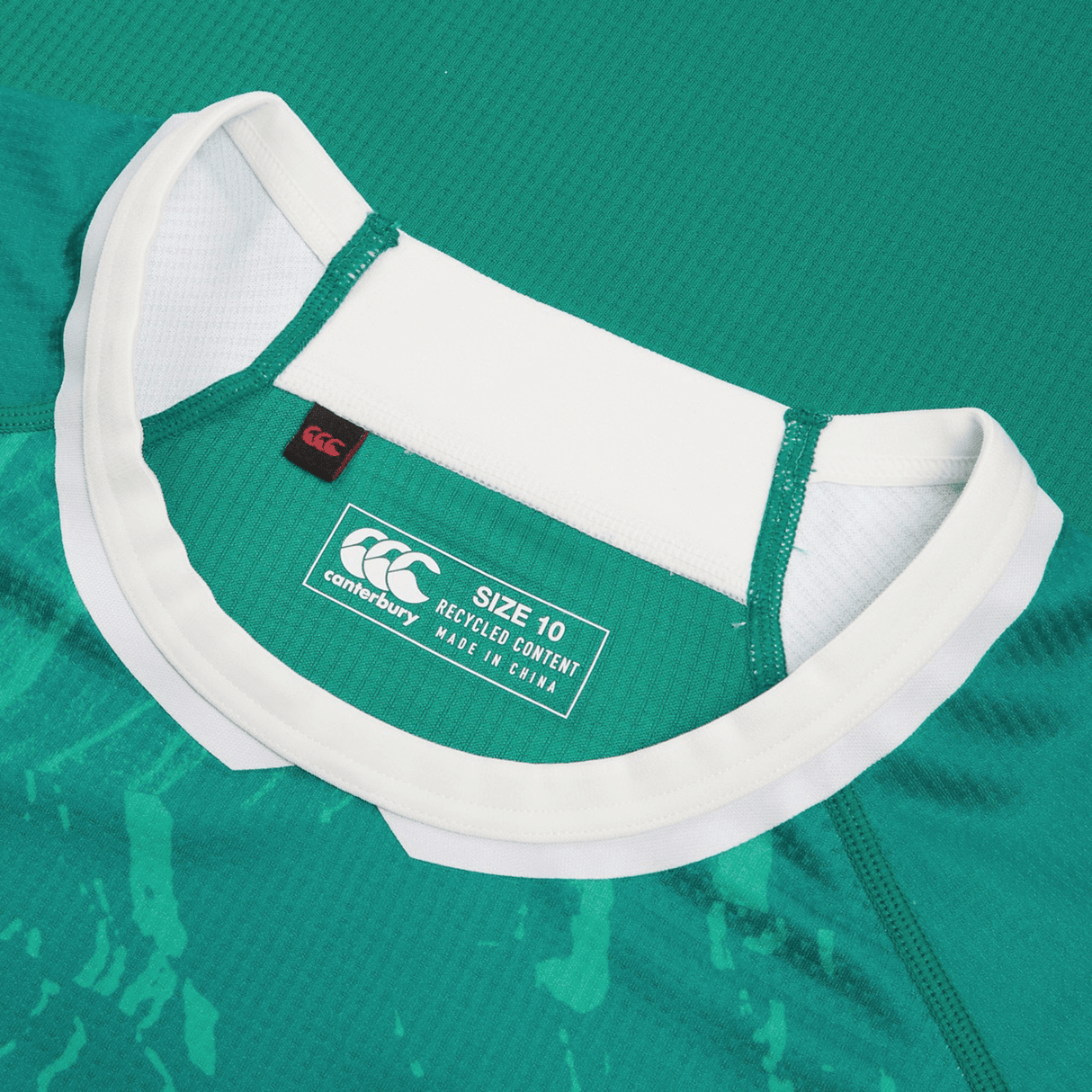 Close-up of a green Women's Ireland WIRFU Home Pro Jersey by Canterbury with a white collar. It features the Official IRFU crest, "Canterbury" label, "Size 10," "Recycled Content," and "Made in China." VapoDri technology enhances comfort.