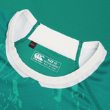 Close-up of a green Women's Ireland WIRFU Home Pro Jersey by Canterbury with a white collar. It features the Official IRFU crest, "Canterbury" label, "Size 10," "Recycled Content," and "Made in China." VapoDri technology enhances comfort.