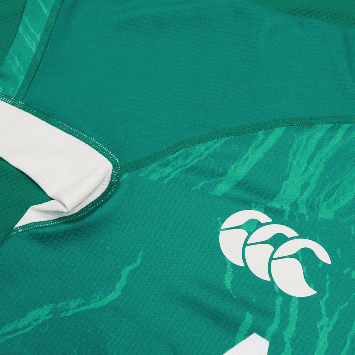 Detailed view of a Women's Ireland WIRFU Home Pro Jersey from Canterbury, featuring the official IRFU crest in white on stylized patterns. This green jersey, enhanced with VapoDri technology, combines style and performance.