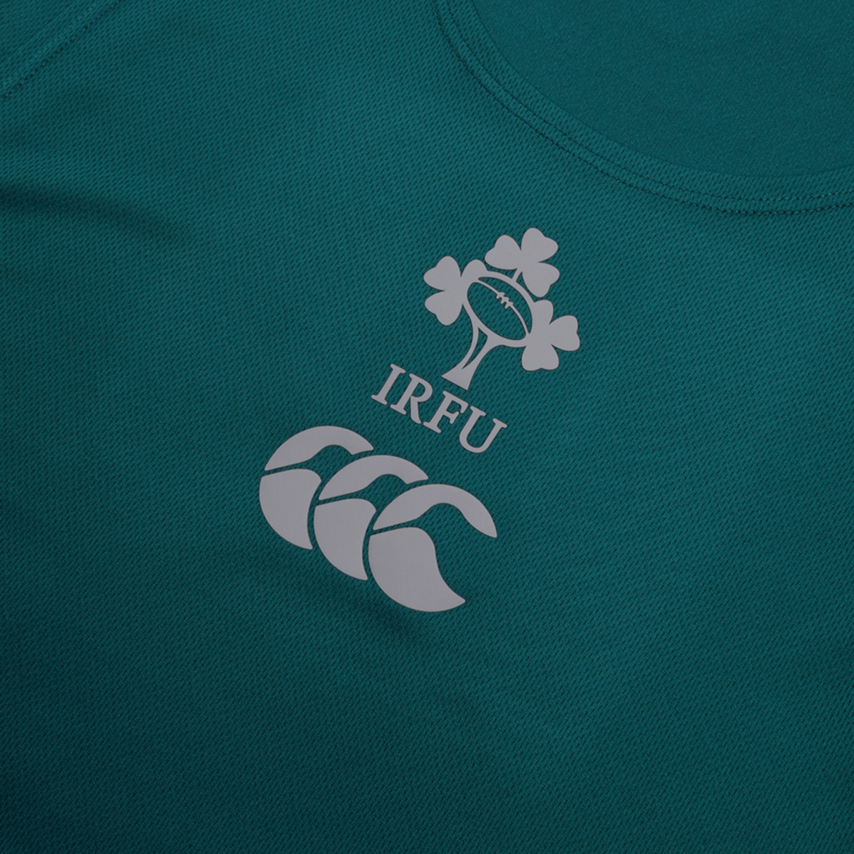 A detailed view of the IRFU logo, featuring a shamrock and rugby ball design, appears on the green Ireland 24 Poly Training Singlet by Canterbury. The stylized CCC logo is also shown, and the singlet is made from quick-drying fabric.
