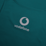The Canterbury Ireland 24 Poly Training Singlet features quick-drying green fabric with a white Vodafone logo and circular design above it.
