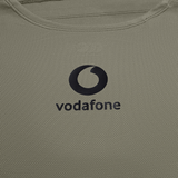 Close-up of the Ireland 25/26 Poly Training Singlet by Canterbury, featuring beige fabric and the Vodafone logo printed in black.