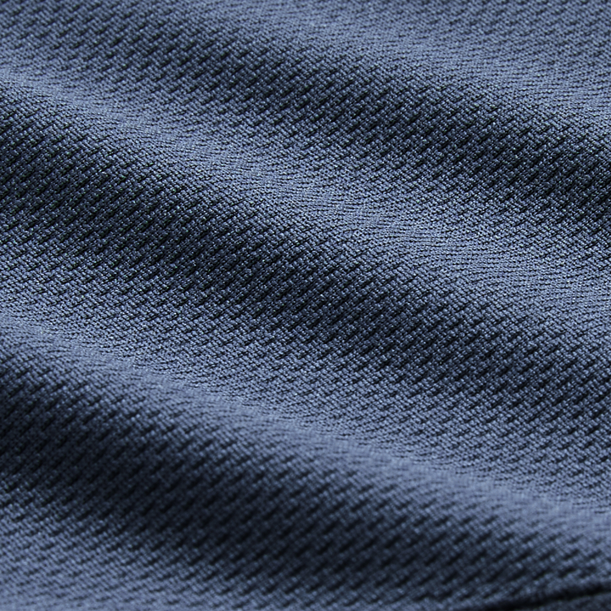 Close-up of dark blue textured fabric with a diagonal weave and soft folds, showcasing the premium quality of the Canterbury Ireland 26/27 Summer Tour Superlight Training Singlet.