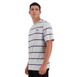 A person stands wearing a grey, short-sleeved Canterbury Yarn Dye T-Shirt with purple horizontal stripes and a small graphic on the left chest, made from 100% cotton by Canterbury.