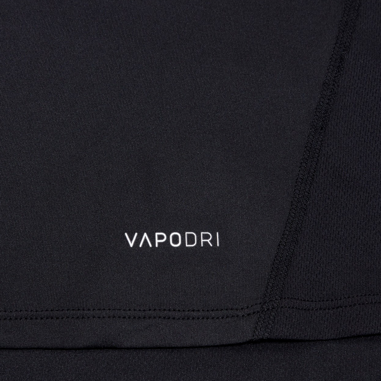 Close-up of a black Canterbury Large Logo Superlight Tee AM with visible stitching and "VAPODRI" in white, highlighting the brand's moisture-wicking technology.