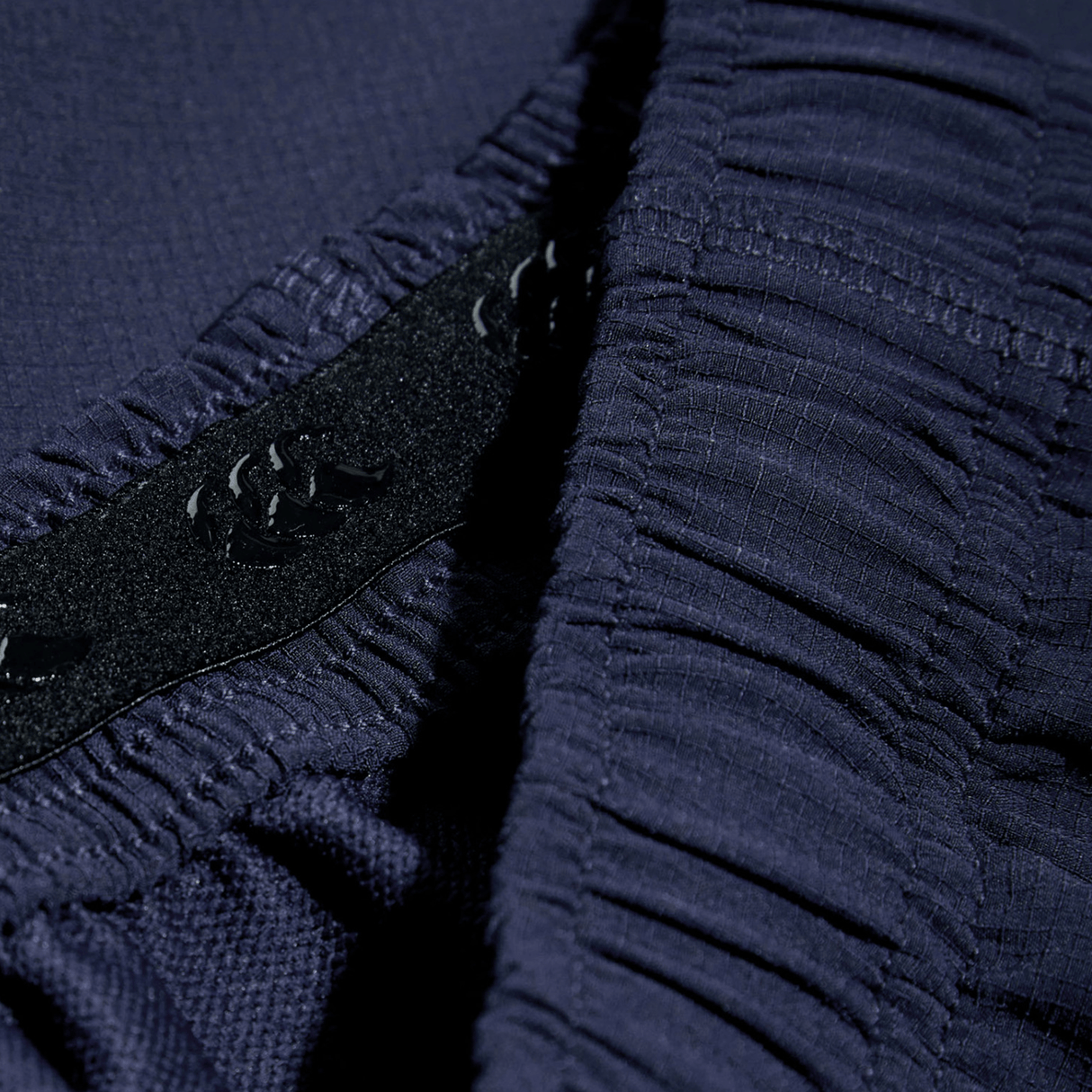 A close up of the Canterbury Yokohama Short button on a blue shirt by Canterbury.