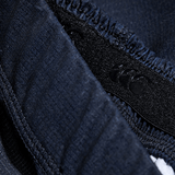 Close-up of the navy woven texture fabric and stitched seam of the Women's Canterbury Yokohama Short 3-Pack Bundle by Bundle Canterbury, showcasing a small black logo on a tag. This durable material is ideal for providing strength and reliability during women's intense rugby matches.