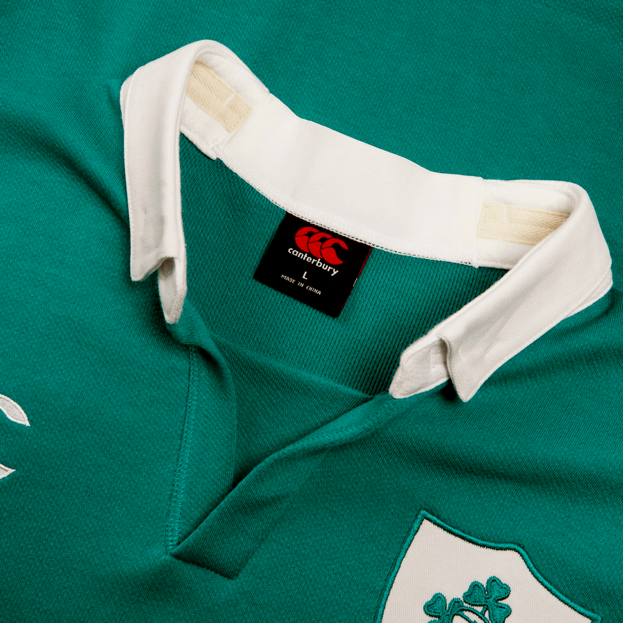 The Ireland 24 Home Classic Jersey by Canterbury is a green rugby jersey with a white collar, showcasing Irish spirit. It features a logo on the chest and has a Canterbury brand tag inside.