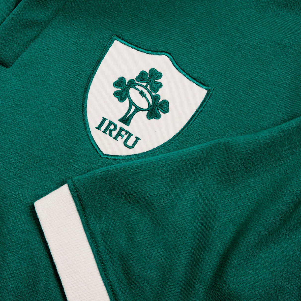 The Ireland 24 Home Classic Jersey by Canterbury features a green fabric with a white rugby emblem of a ball and three clovers, labeled "IRFU," capturing Irish tradition and pride.