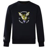 The Hornets Rugby Club 1977 Club Crew Sweatshirt by Canterbury, from WRS Canterbury, is a black crew sweatshirt featuring a yellow hornet graphic and "hornets 1977 RUGBY CLUB" text on the front, along with an embroidered CCC logo on the left sleeve. Designed as an ultra soft sweatshirt for everyday comfort.