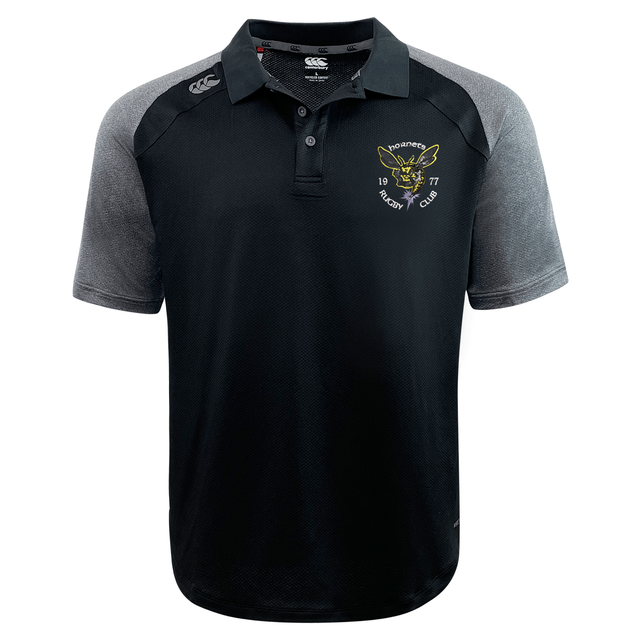 The Hornets Rugby Club 1977 Elite Polo by Canterbury is a black and gray short-sleeve shirt featuring the “Hornets Rugby Club” logo and a hornet graphic on the left chest, along with a white EMB Canterbury logo on the right shoulder. Made from lightweight, durable Vapodri fabric, this polo delivers exceptional comfort and breathability both on and off the field.