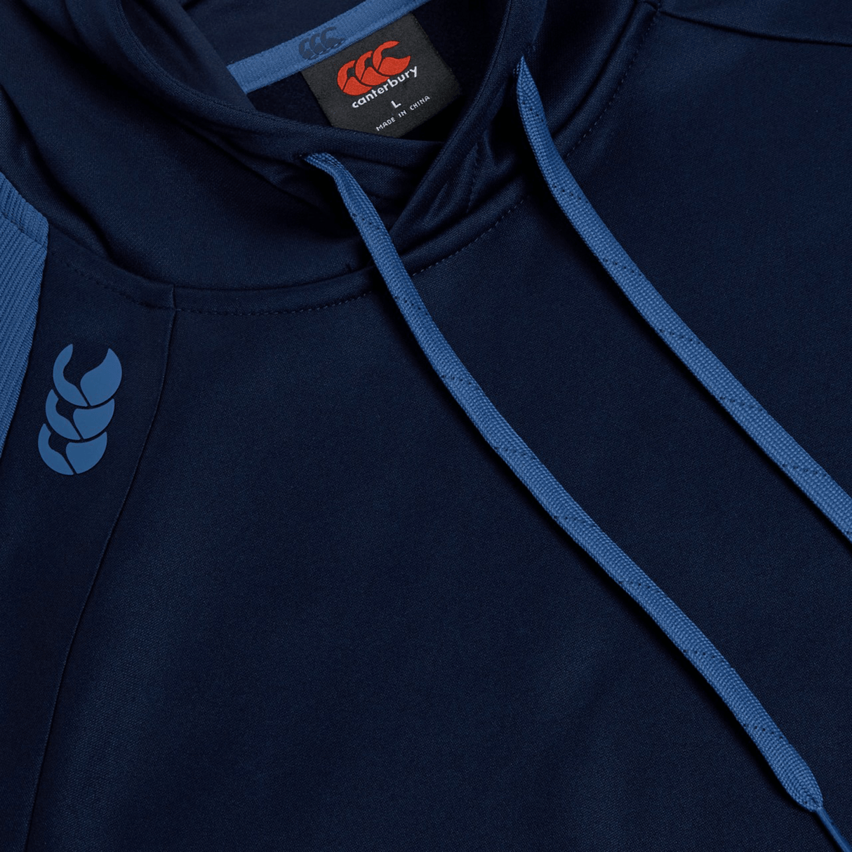 Close-up of the Canterbury Elite Training Hoodie in navy blue, featuring light blue drawstrings and the Canterbury logo on the shoulder and tag. This hoodie is crafted from premium fabrics for a comfortable and versatile fit.