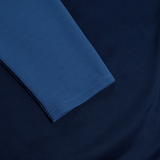 Close-up of the Canterbury Elite Training Hoodie in blue, made by Canterbury using premium fabrics, laid flat on a navy blue surface.