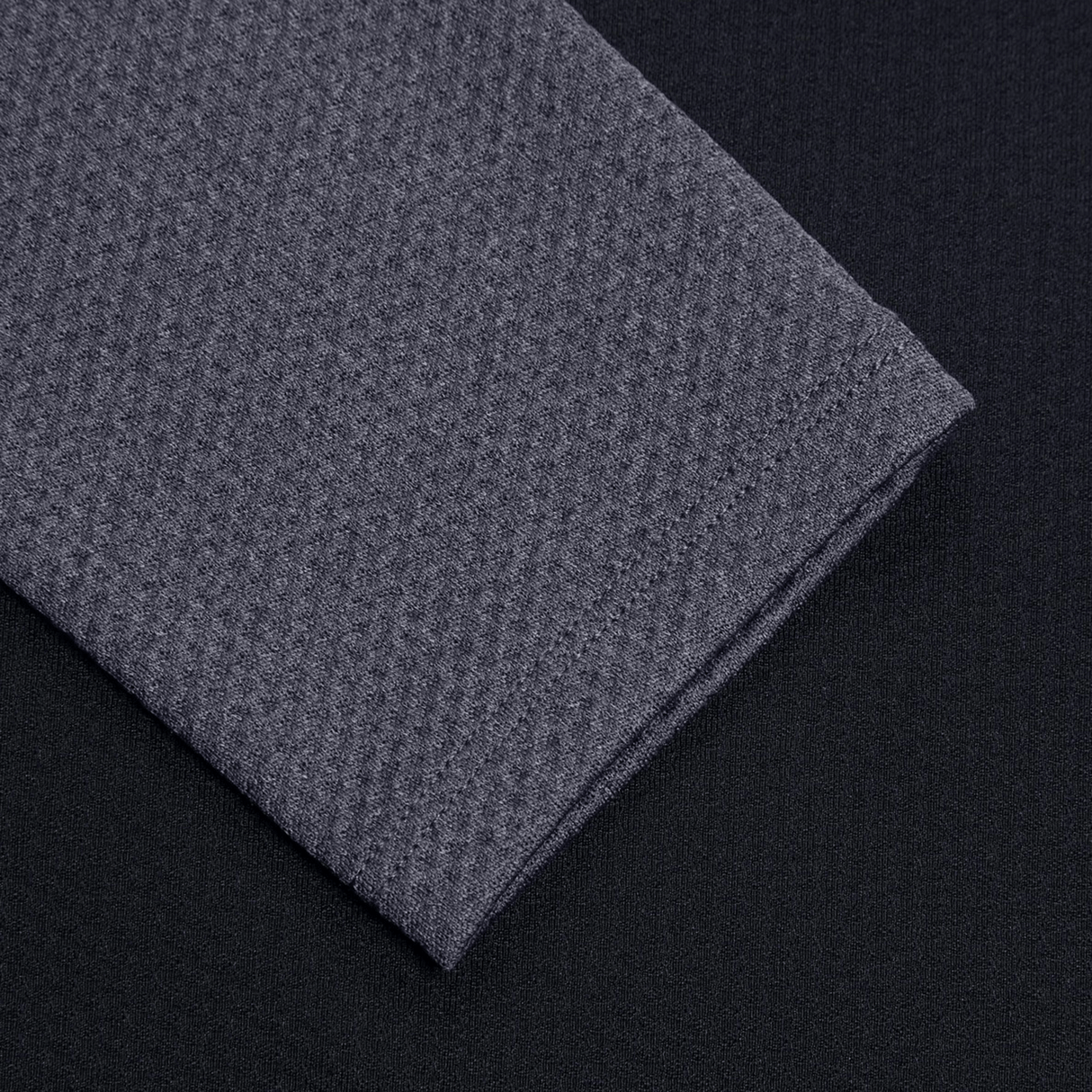 Discover the Women's Canterbury Elite First Layer by Canterbury, featuring a sleek black surface adorned with subtly elegant folded gray fabric in a honeycomb-inspired textured pattern.