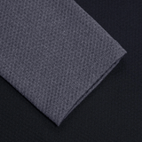 Discover the Women's Canterbury Elite First Layer by Canterbury, featuring a sleek black surface adorned with subtly elegant folded gray fabric in a honeycomb-inspired textured pattern.