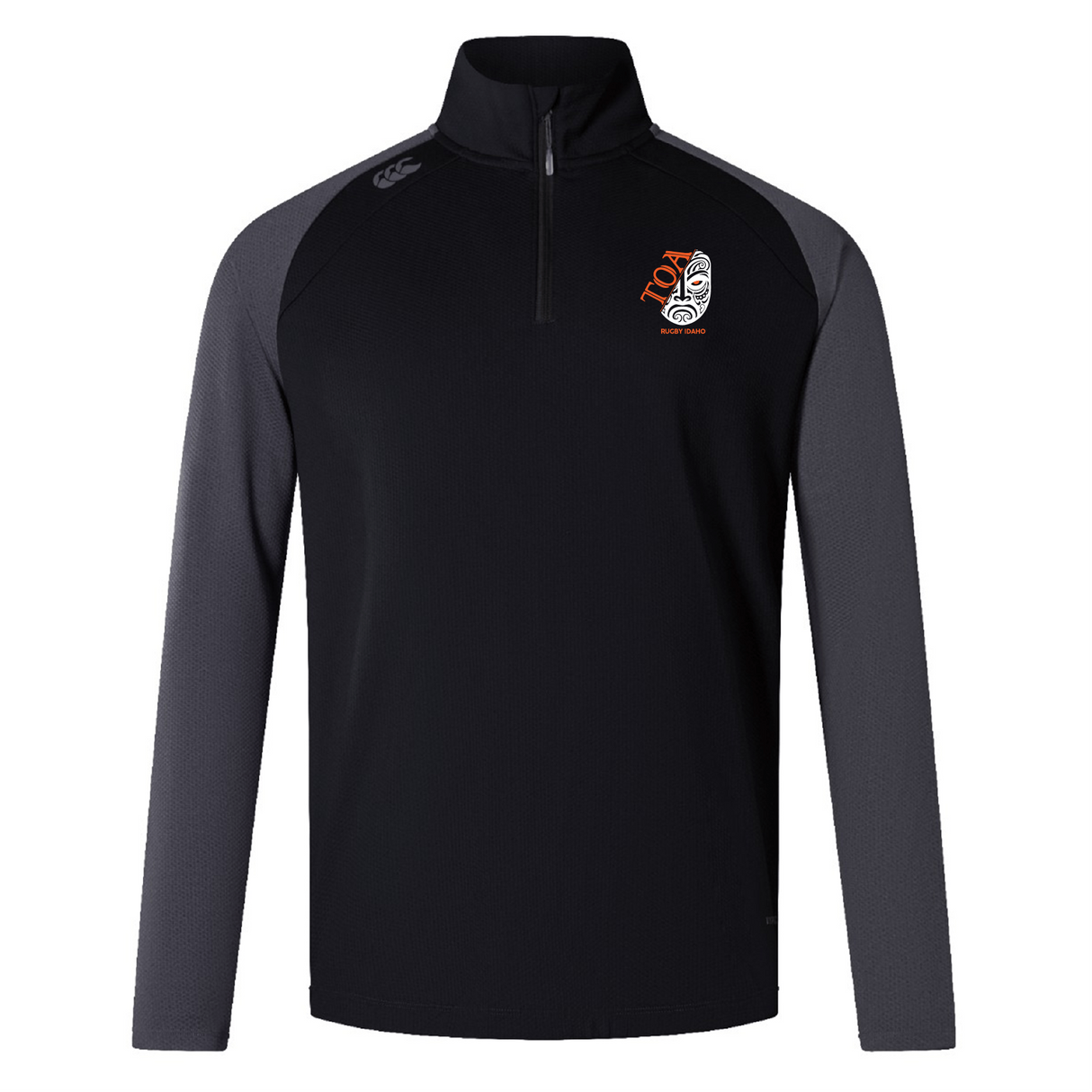 The Toa Rugby Idaho Women's Elite First Layer by EMB Canterbury, features VapoDri tech for comfort. This long-sleeve, black and gray pullover includes a quarter-zip, Canterbury logo near the collar, and a stylized mask emblem on the chest that blends style with performance.